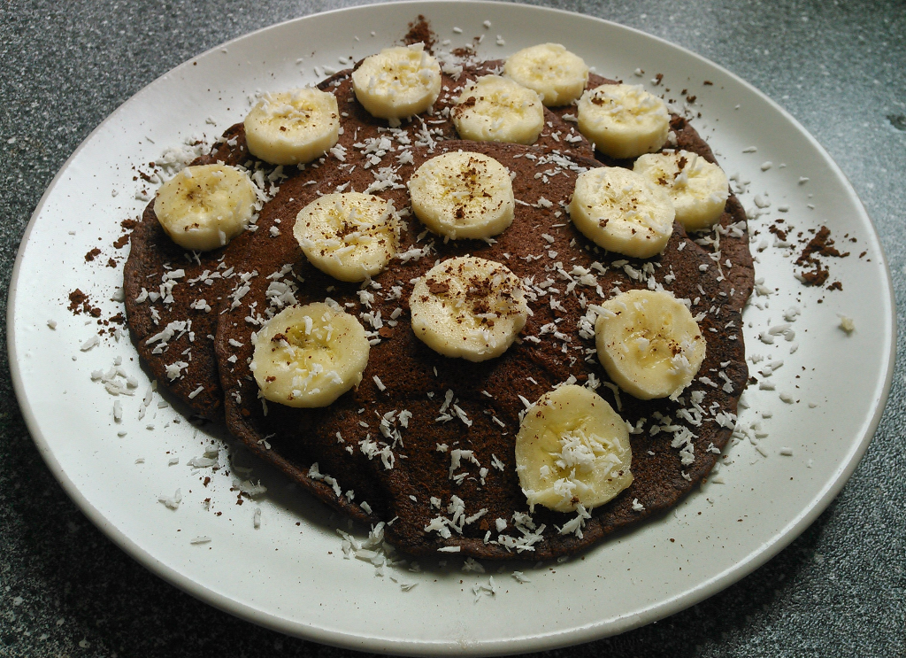 Schokopfannkuchen mit Bananenscheiben und Kokosraspeln belegt