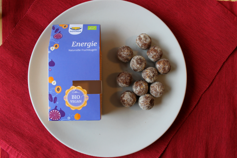 Fruchtkugel "Energie" von Govinda, links Verpackung, rechts Fruchtkugeln