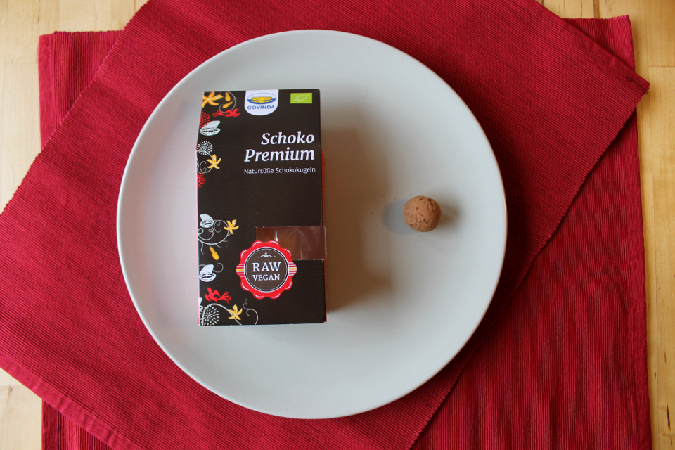 Schokokugel "Schoko Premium" von Govinda, links Verpackung, rechts Schokokugel