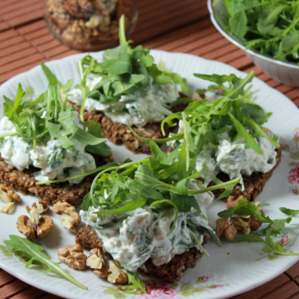 Frischkäse-Aufstrich mit Vollkornbrot angerichtet auf Teller