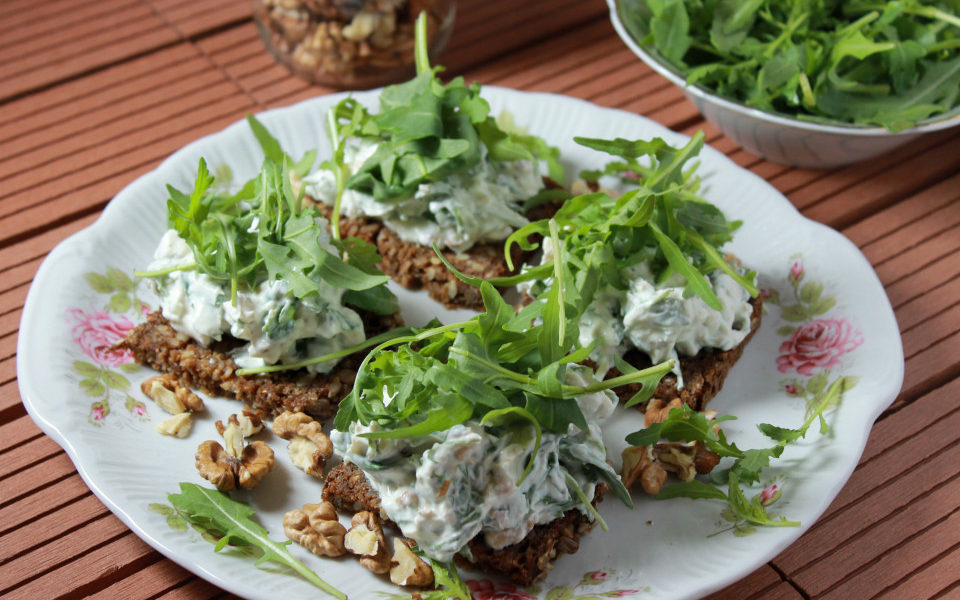 Frischkäse-Aufstrich mit Vollkornbrot angerichtet auf Teller